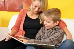 Eine Frau liest einem Jungen aus einem Buch vor.