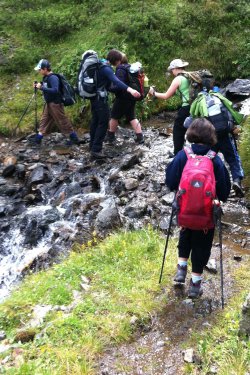 Wanderer &uuml;berqueren einen Bach
